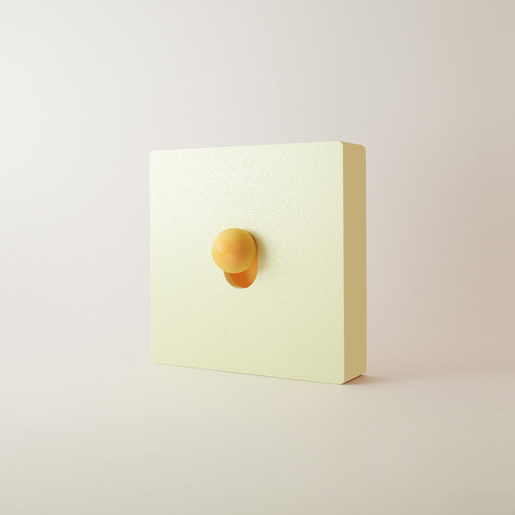 Cache interrupteur Ivoire monobloc ivoire, façade et cadre en une seule pièce, bouton jaune ambre