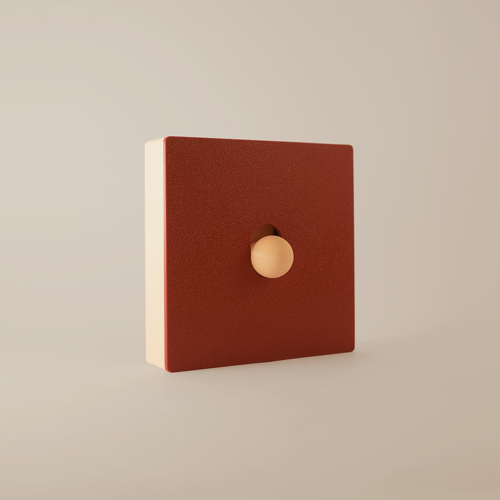 Cache interrupteur Érable modulable, façade rouge érable aimantée sur cadre beige, vue de trois-quarts