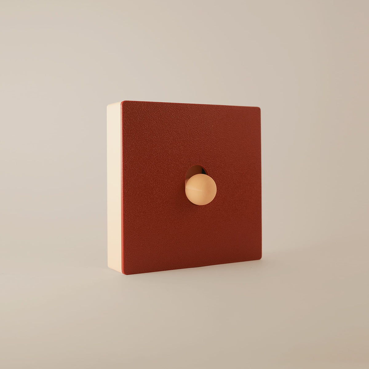 Cache interrupteur Érable modulable, façade rouge érable aimantée sur cadre beige, vue de trois-quarts